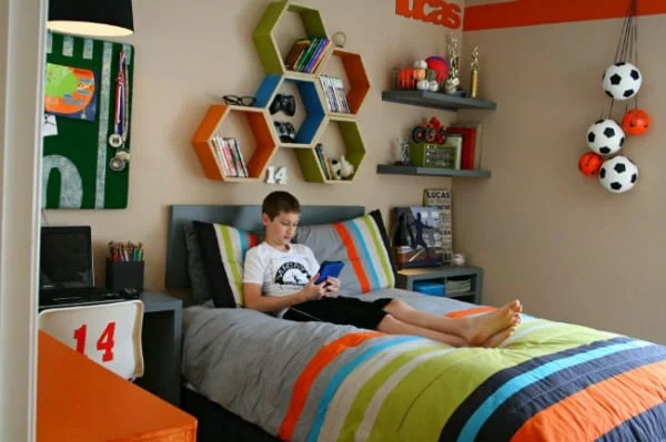 teenage boy sitting in his sports themed bedroom