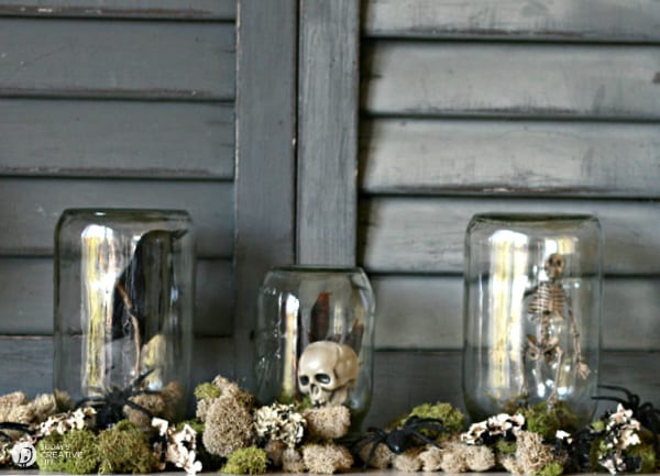 3 jars upside down with halloween decor inside.