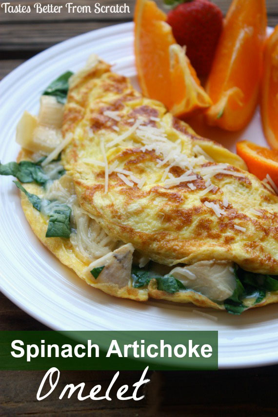 Spinach Artichoke Omelet served on a plate with orange wedges. 