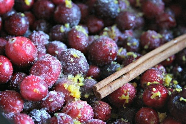 cranberries, cinnamon sticks, and orange zest in a slow cooker to make crockpot cranberry orange sauce