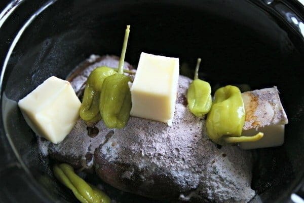 beef chuck roast with pepperoncinis ready to be cooked in a crock pot