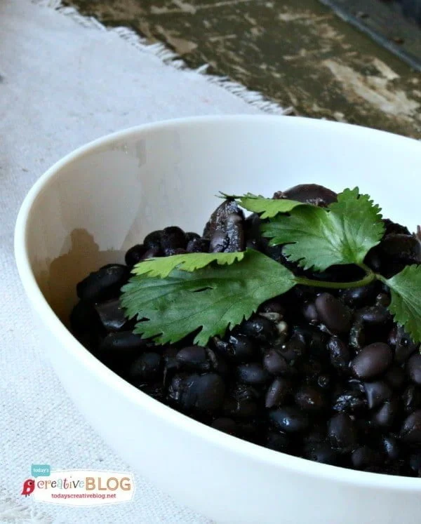 Slow Cooker Seasoned Black Beans No Soak in a white bowl with green cilantro on top