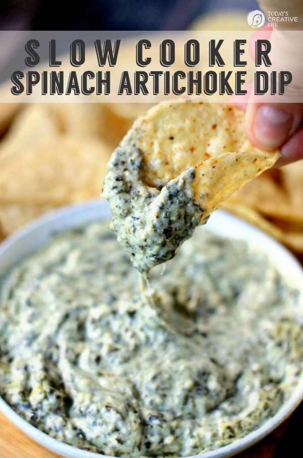 hot cheesy spinach artichoke dip on a tortilla chip
