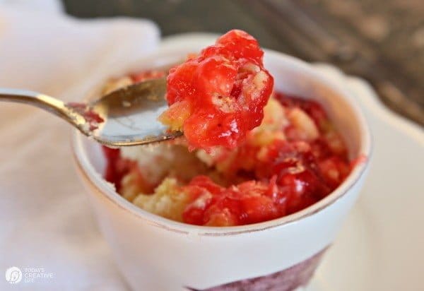 Strawberry Dump Cake being spooned up. 