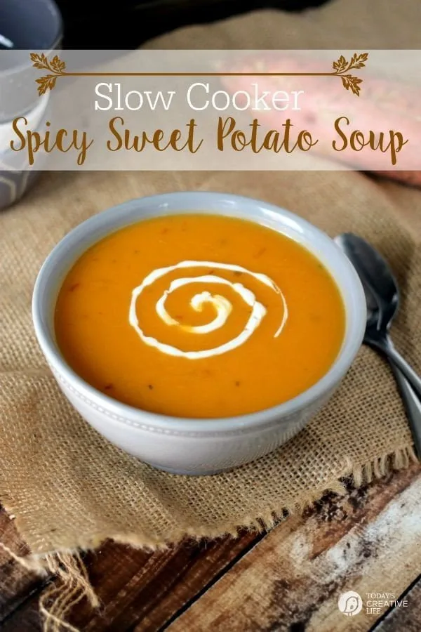 Slow Cooker Spicy Sweet Potato Soup served in a white bowl with sour cream swirled. 