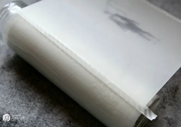 Taping sheer frosty paper to a jar candle