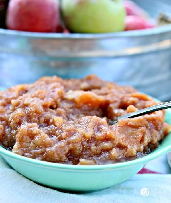 Homemade crockpot applesauce | Small bluish bowl filled with chunky applesauce.