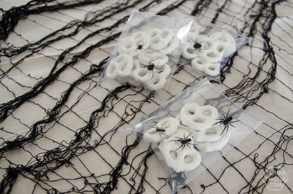 Clear pocket envelopes with black spider stickers, filled with white pretzels