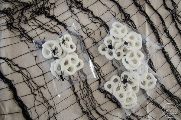 Clear pocket envelopes with black spider stickers, filled with white pretzels