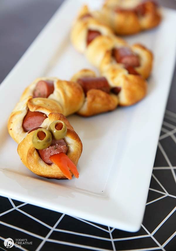 Snake made with crescent rolls and hot dogs for fun Halloween food ideas.