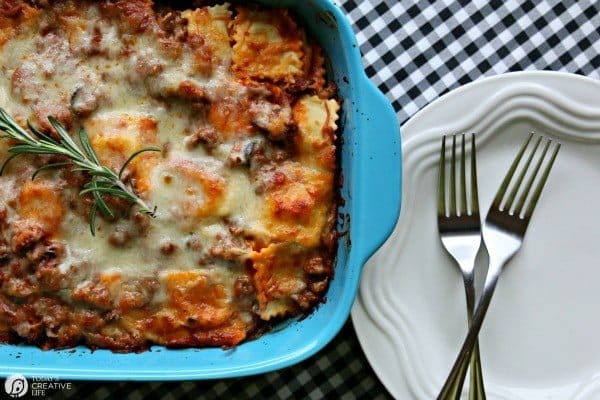 Ravioli Casserole sitting next to white dinner plates