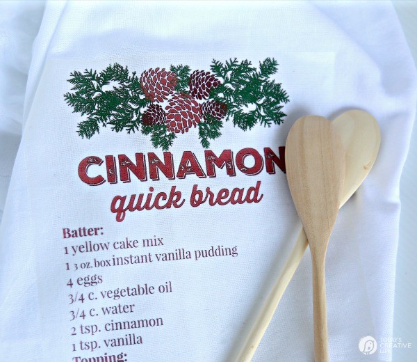cotton dish towel with a recipe printed on it, along side 2 wooden spoons. 