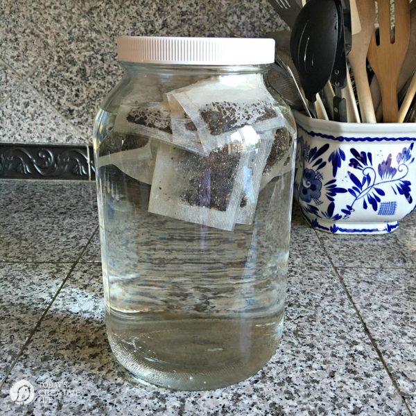 making sun tea in a large jar of water with tea bags