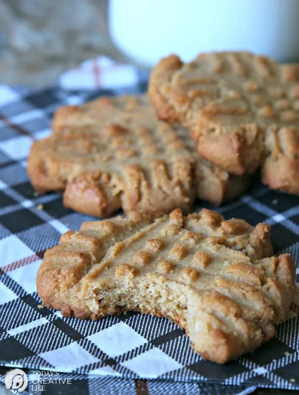 stack of peanut butter cookies. One has a bite taken out of it