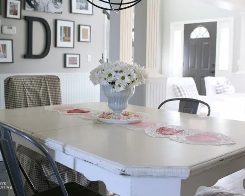 10 Minute Valentines Table Decor | create a quick, simple and easy Valentine's Day decorations tablescape centerpiece with a heart shape doily table runner, conversation hearts and daisies. See more on Today's Creative Life.