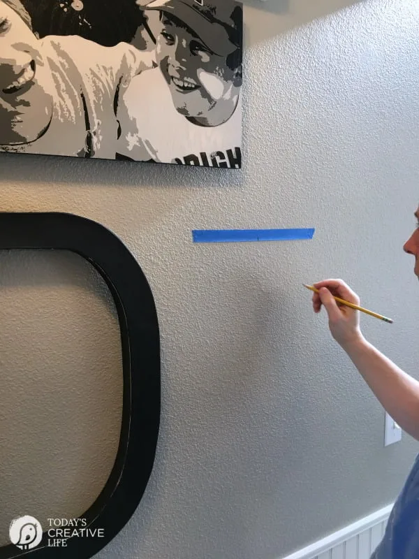 marking a wall for hanging photos