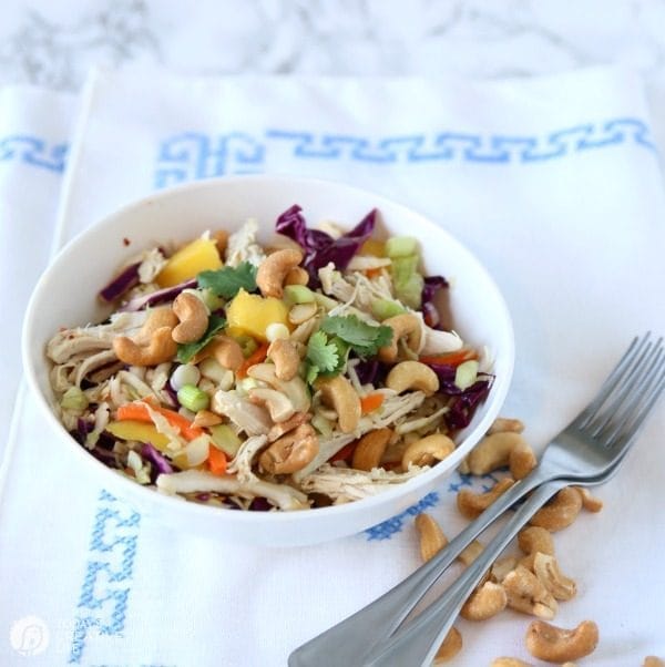 Bowl of salad with cashews, cabbage and mango.