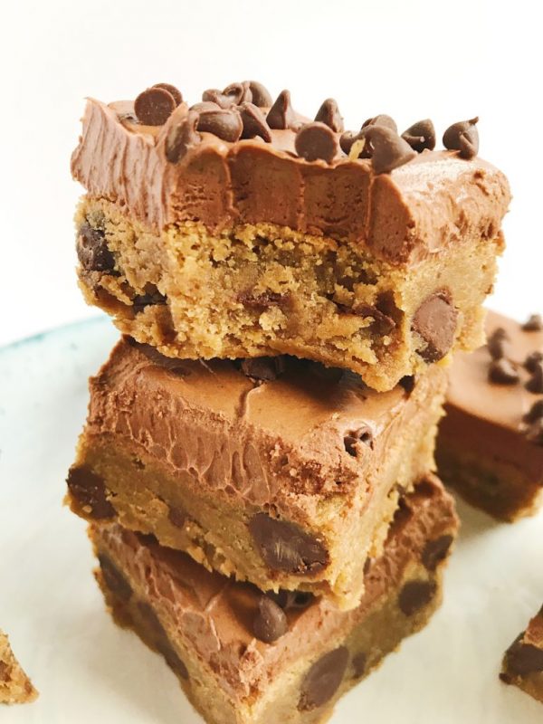 stack of frosted Peanut Butter Brownies with a bite taken out of one