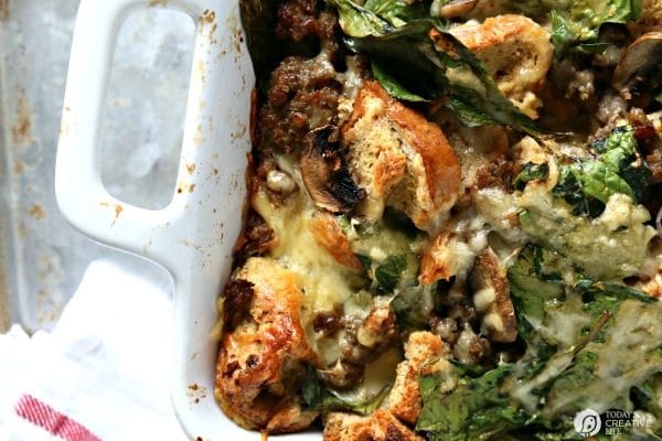 casserole dish of baked eggs with sausage, vegetables, and rye bread