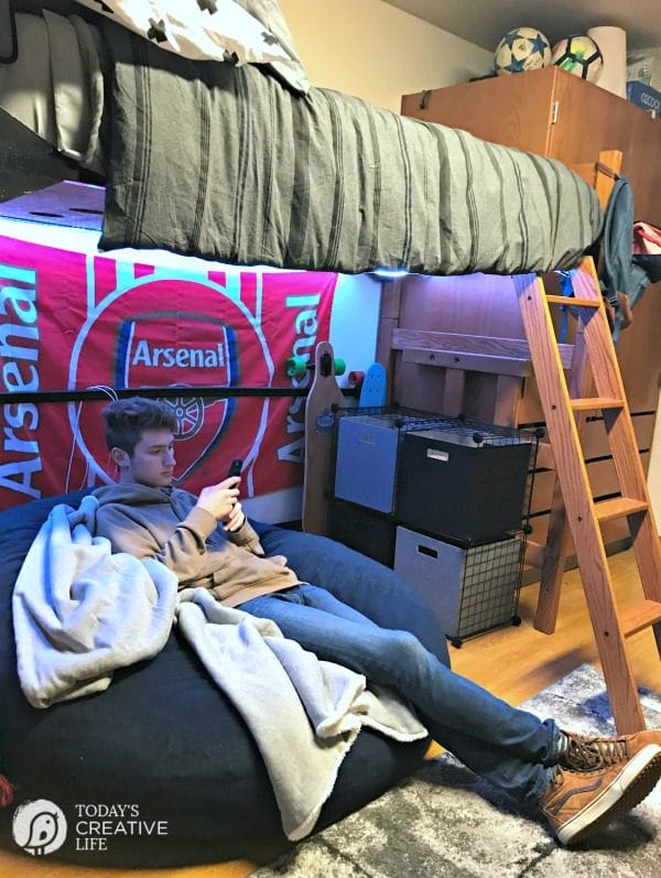 Dorm Room Ideas for Boys | dorm room ideas for guys | college male sitting in dorm room on bean bag chair. 