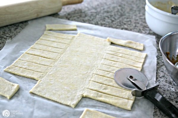 using a pizza cutter to create a puff pastry braid