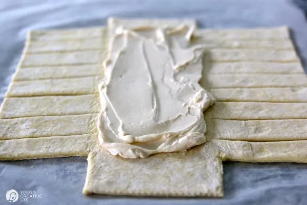 cream cheese filling spread on top of puff pastry dough