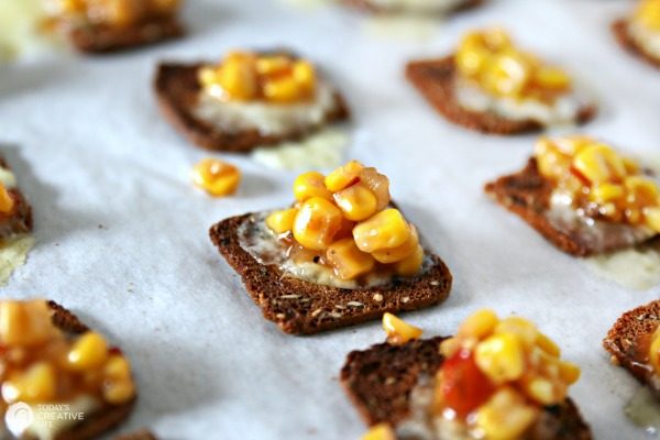 Brie and Corn Salsa Bites lined up on a baking sheet for easy appetizers. 