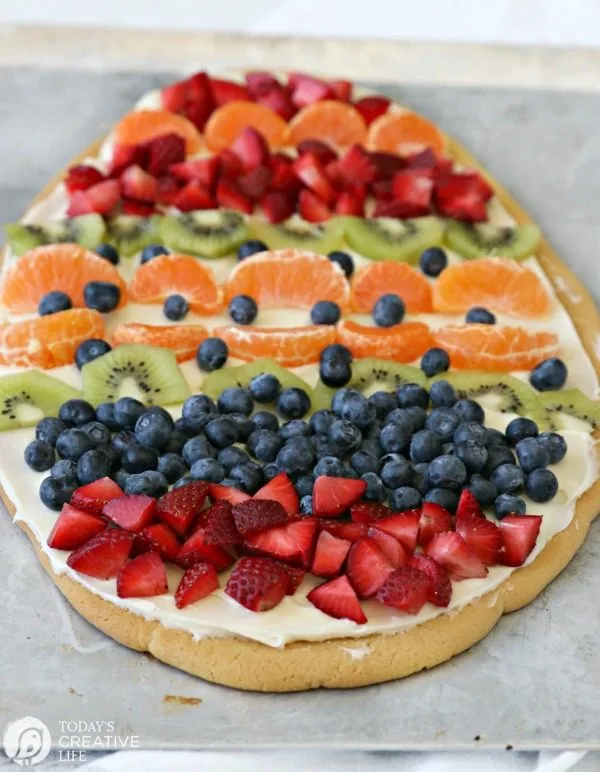 Sugar Cookie Easter Egg Fruit Pizza | Easy to make Easter treat. Cream Cheese frosting topped with your favorite fruits | Colorful Spring Dessert Ideas | TodaysCreativeLife.com