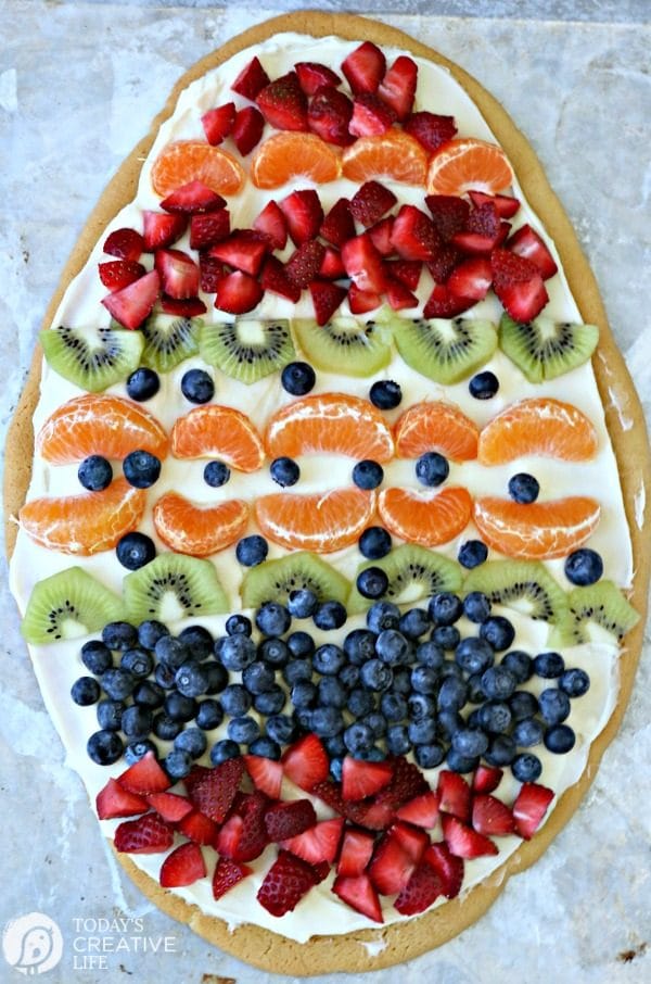 Sugar Cookie Easter Egg Fruit Pizza | Easy to make Easter treat. Cream Cheese frosting topped with your favorite fruits | Colorful Spring Dessert Ideas | TodaysCreativeLife.com