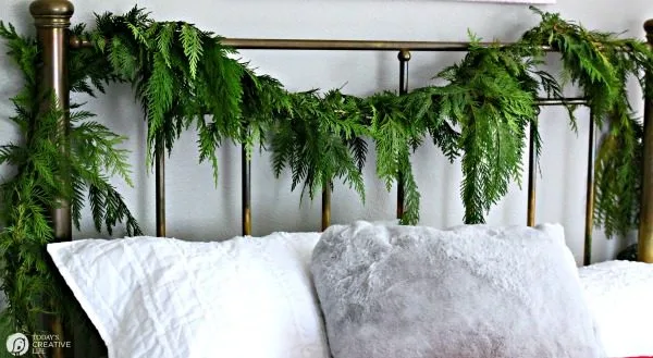 fresh garland hanging on a bedroom headboard