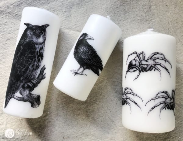 3 candles with halloween images on them.