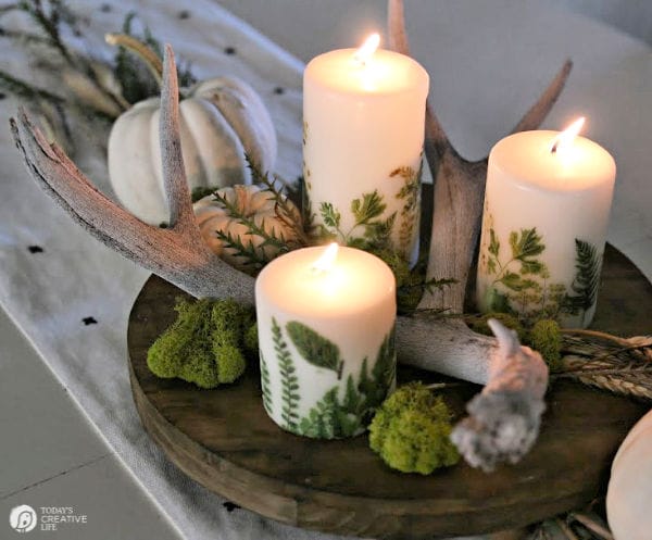 Candles lit in fall table centerpiece. 