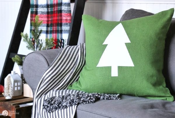 Holiday setting with green pillow with a white tree on it