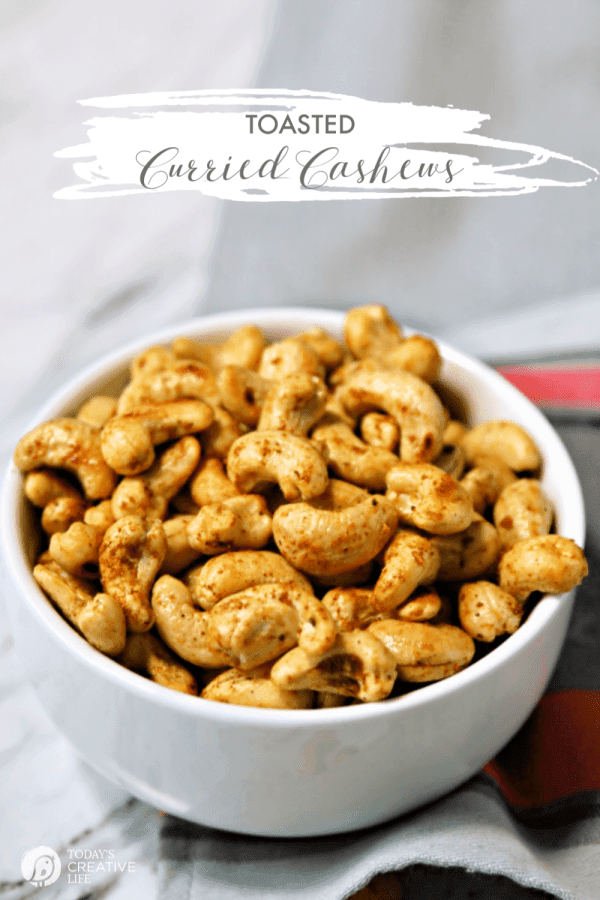 White bowl full of seasoned cashews.