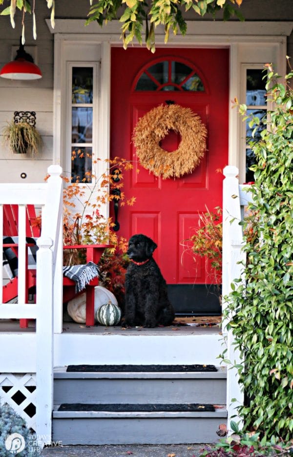 Porch with Red door decorated for Fall.