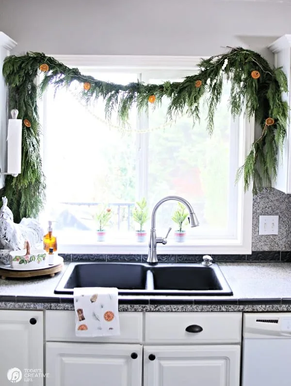 Cedar Garland with oranges over a kitchen sink window. 