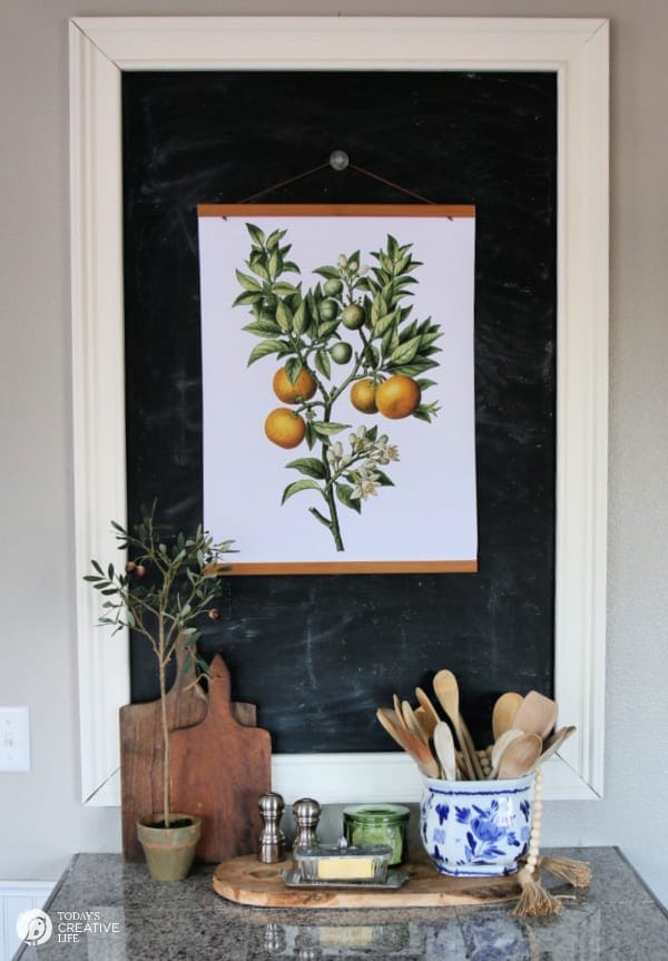 Large chalkboard with hanging botanical print of oranges.