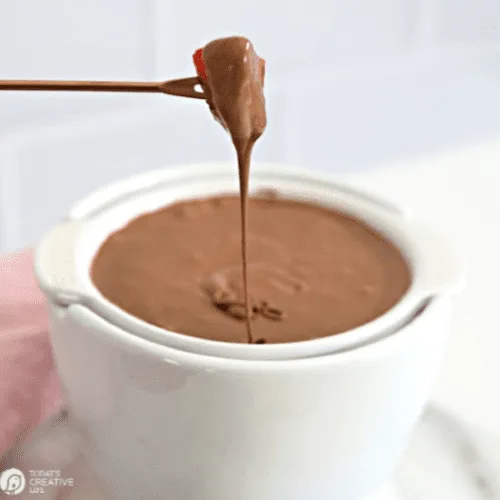 bowl of chocolate fondue with cake dipped.