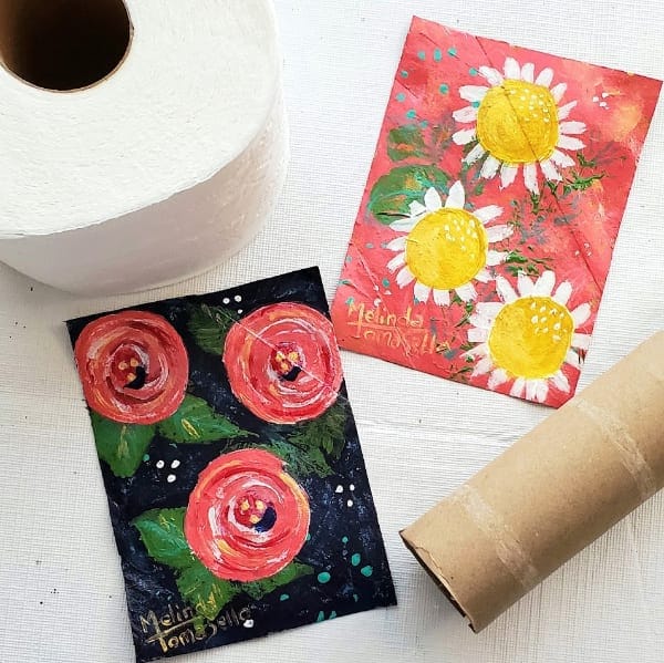 Flattened cardboard toilet paper rolls with painted art