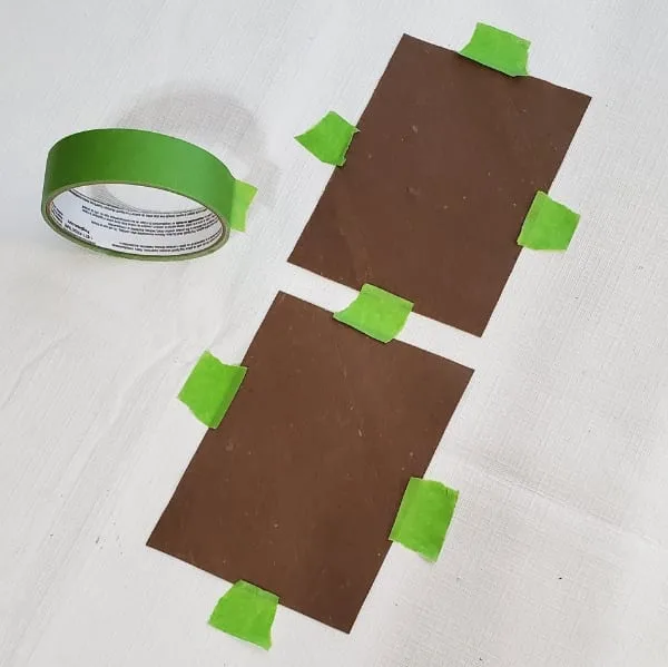 Taping down wet cardboard squares to dry