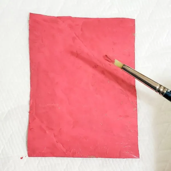 Pinked painted flat piece of toilet paper roll cardboard