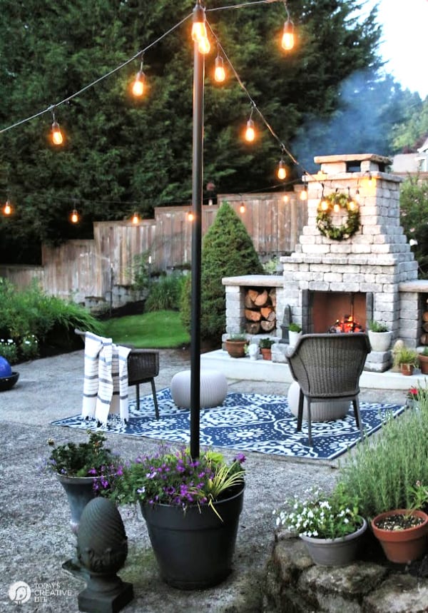 Backyard with fireplace and string lights.