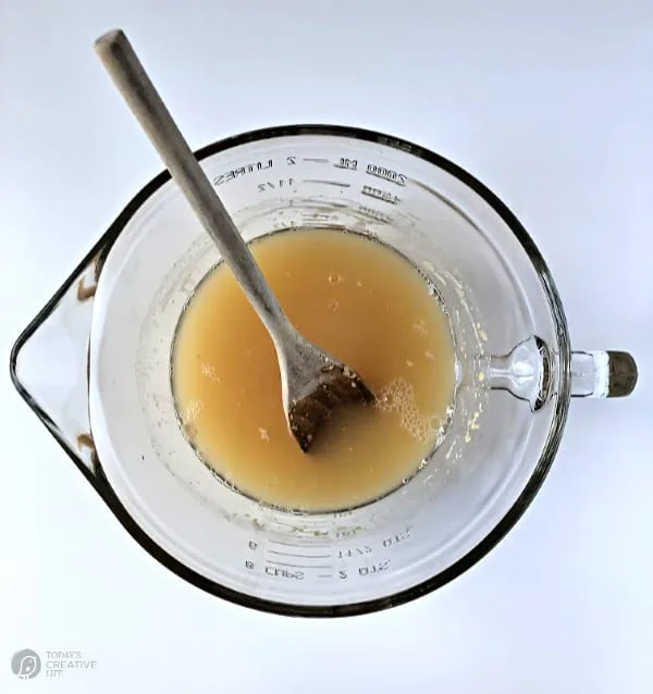 clear glass bowl with beer, yeast and sugar mixed together.