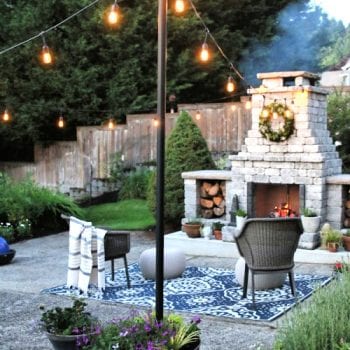 Outdoor hanging lights with outdoor fireplace.