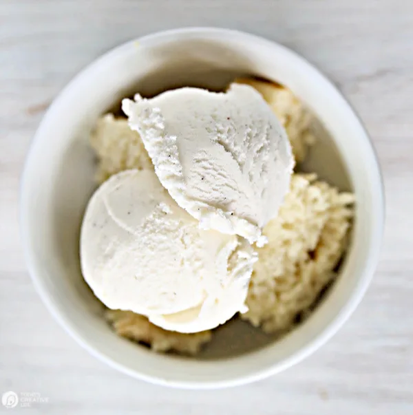 White bowl with cubed cake and 2 scoops of ice cream