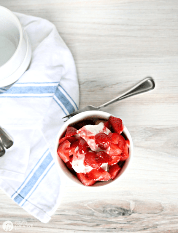 white bowl of ice cream and strawberries