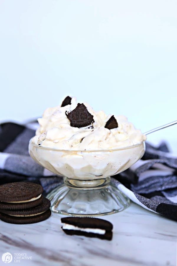 Dessert cup with white fluffy dessert topped with crumbled oreos. 