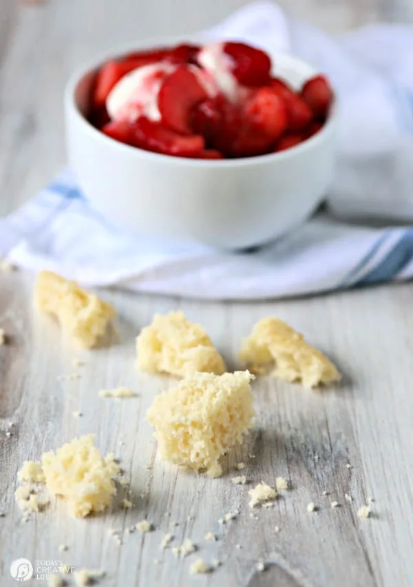 Bowl of strawberries with cake on counter