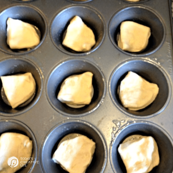 Muffin Tin with quartered biscuit dough