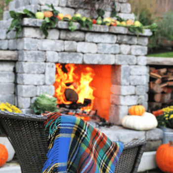 Outdoor Fall Decorating Ideas | outdoor fireplace with a roaring fire.